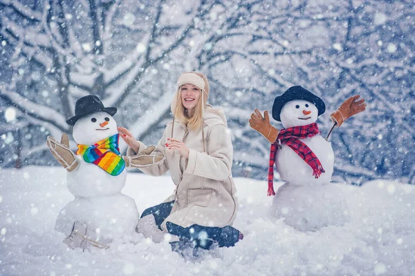 Зимова дівчинка. Щаслива молода жінка грає зі сніговиком на сніжній зимовій прогулянці. Зимові емоції. Молода жінка зимовий портрет. різдвяні люди . — стокове фото