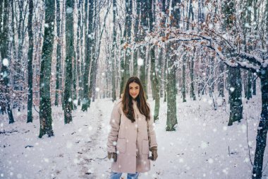 Seksi esmer kış kız poz ve eğleniyor. Gülen kız açık havada.