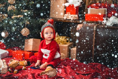 Karda Noel çocukları. Noel oyuncakları ve mutlu çocukluk. Mutlu Noeller ve mutlu yıllar. Noel ağacı arka planında şirin bir çocuk..