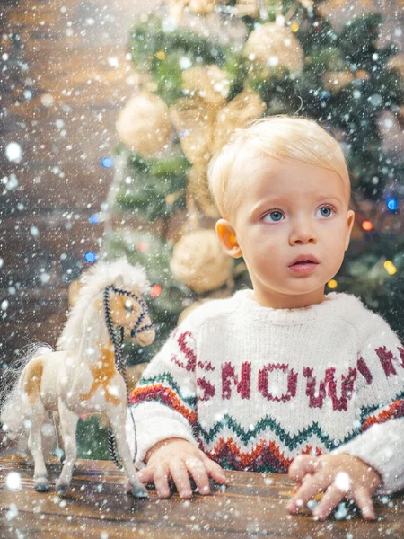 Weihnachtskinder im Schnee. glückliches Kind mit Weihnachtsgeschenkbox. fröhliches süßes Kind, das ein Weihnachtsgeschenk öffnet. Niedliches kleines Kind schmückt den Weihnachtsbaum drinnen. Kind genießt den Urlaub. — Stockfoto