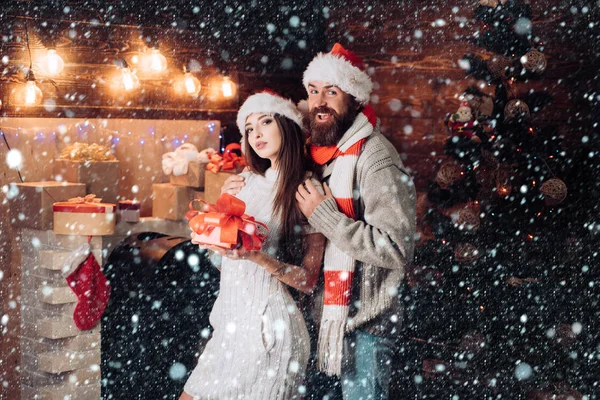 Christmas couple in snow. Joyful friends in christmas at home. Christmas married couple. Best friends. Happy married couple with christmas gift box. Merry Christmas and Happy Holidays.