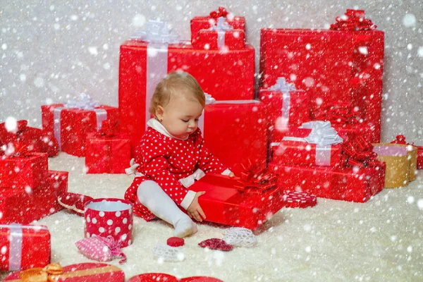 Niños de Navidad en la nieve. Christmas Girl - Efectos de la nieve. Niño divertido bebé con regalo. Concepto de bebés de vacaciones. Niño con un regalo . — Foto de Stock