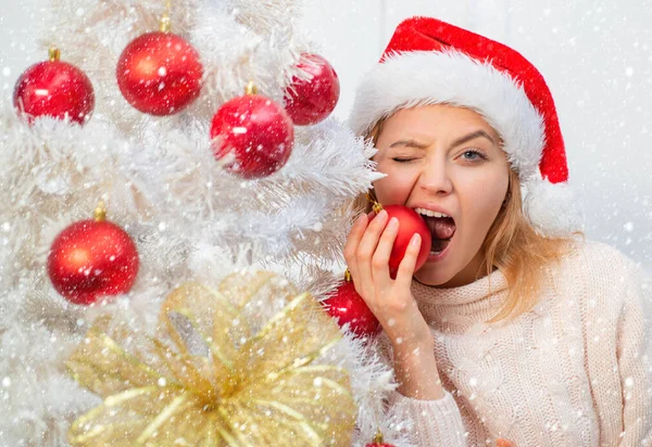 Kardaki kadın. Beyaz Noel ağacı kırmızı topları. Evde Noel Şapkalı Güzel Kadın. Size mutlu noel ağaçları, zarif bir parti eğlencesi diliyoruz. Noel Baba eğlencesi Olumlu insan duyguları yüz ifadeleri. — Stok fotoğraf