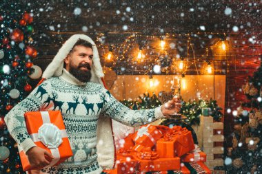 Kardaki Noel adamı. Noel Baba şapkalı adam. Sakallı, modern Noel Baba örgü süveter giymiş. Yeni yıl konsepti. Yeni yıl partisi.