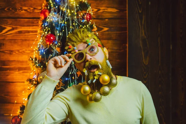 Αστείος άνθρωπος Σάντα θέτει σε vintage ξύλινο φόντο. Οι άνθρωποι των Χριστουγέννων γιορτάζουν την Πρωτοχρονιά. Ευτυχισμένος Άγιος Βασίλης ντυμένος με χειμωνιάτικα ρούχα σκεφτείτε τα Χριστούγεννα κοντά στο χριστουγεννιάτικο δέντρο. — Φωτογραφία Αρχείου
