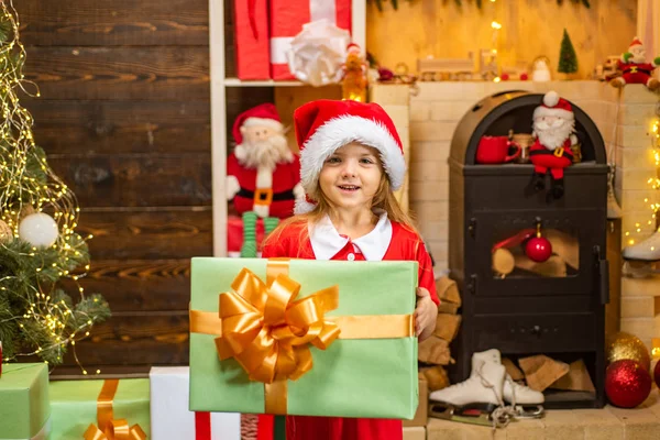 Um miúdo engraçado a segurar um presente de Natal. Na manhã anterior ao Ano Novo. Crianças de Natal - conceito de felicidade. Crianças de Natal . — Fotografia de Stock