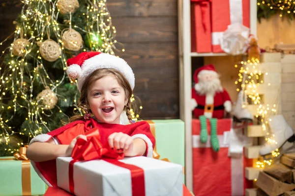 Noworoczne dzieciaki. Wesoły słodkie dziecko otwierając prezent świąteczny. Boże Narodzenie dziecko trzyma czerwone pudełko z prezentami. Święta Bożego Narodzenia. — Zdjęcie stockowe