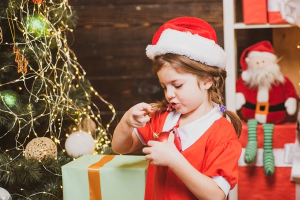 Criança feliz vestida com roupas de inverno pense no Papai Noel perto da árvore de Natal. Crianças de Natal. Ano Novo e conceito de crianças de Natal . — Fotografia de Stock