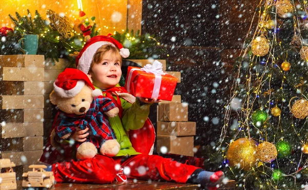 雪の中のクリスマスの子供たち。クリスマスの前夜に夢のような赤ちゃんの幼児。クリスマスの奇跡を信じなさい。サンタ・クラスに会いたい冬休みだメリークリスマスと幸せな新年。幸せな子供時代愛らしい — ストック写真