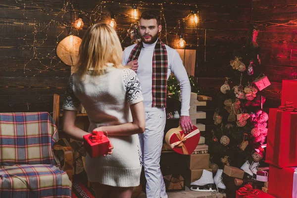 Χριστουγεννιάτικο ζευγάρι ερωτευμένο. Ευτυχισμένη ξανθιά νεαρή γυναίκα και άντρας δίνουν χριστουγεννιάτικα δώρα ο ένας στον άλλον. Υπέροχο ευτυχισμένο ζευγάρι. Υπνηλία. — Φωτογραφία Αρχείου