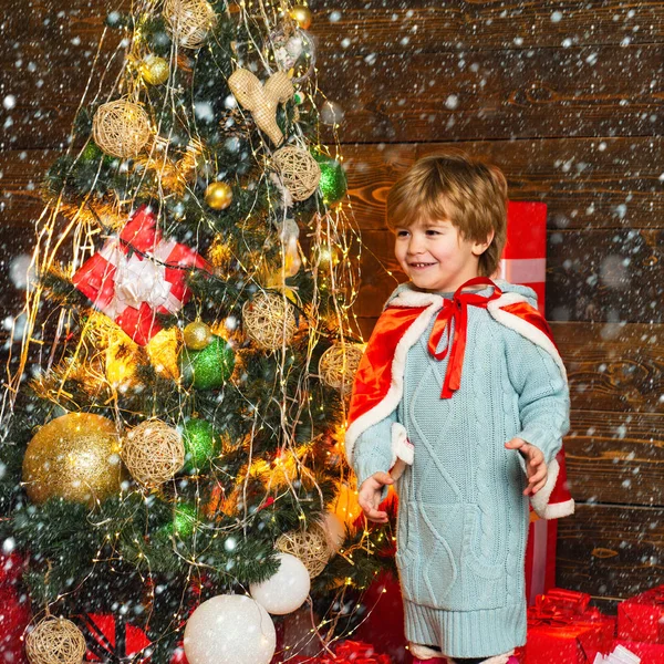 雪の中のクリスマスの子供たち。クリスマスツリーのそばの幸せな男の子。冬、休日、家族の概念. — ストック写真