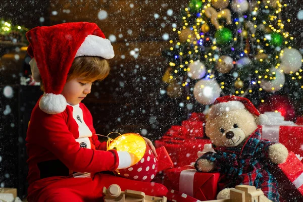 Christmas childs in snow. Boy child play near christmas tree. Merry and bright christmas. Childhood activity and game. Lovely baby enjoy christmas. Family holiday. Childhood memories. Santa boy — Stock Photo, Image