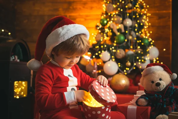 Criança de Natal. Menino sorridente feliz com caixa de presente de Natal. Criança feliz segurando uma caixa de presente vermelha com ambas as mãos. Emoções de presentes. Criança de inverno. Emoção de Natal inverno. — Fotografia de Stock