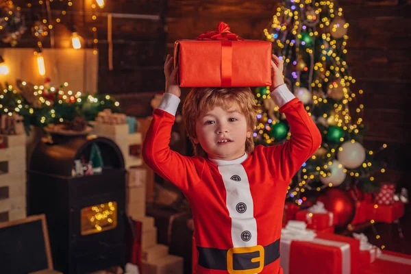 クリスマスの子。クリスマスのギフトボックスと幸せな小さな笑顔の男の子。クリスマスお祝いの休日。かわいい子供たちクリスマスを祝う. — ストック写真