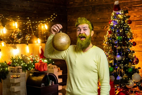 Merry Christmas and happy New Year. Happy winter time. Funny Santa. Portrait of Santa indoors with Christmas ball, gold bauble. — Stockfoto