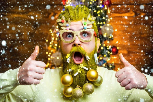 Kerstman in de sneeuw. Fashion portret van knappe man binnen met kerstboom. Nieuwjaarsconcept. Sexy kerstman poseren op vintage houten achtergrond. — Stockfoto