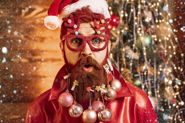 Kerstman in de sneeuw. Knappe man in kerstjurk. Kerstman poseren op vintage houten achtergrond. Kerstmensen vieren Nieuwjaar. — Stockfoto