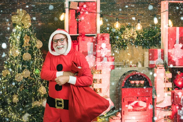 Weihnachtsmann im Schnee. Lustige Weihnachtsmann halten Weihnachtsgeschenk. Weihnachten feiern die Menschen Neujahr. Porträt eines reifen Weihnachtsmannes. — Stockfoto