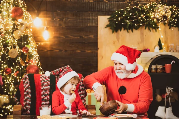 Biscoito de leite e gengibre para Papai Noel contra fundo bokeh luz de Natal. Avô e neto fazem biscoitos de gengibre, perto da árvore de Natal. — Fotografia de Stock