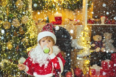 Karda Noel çocukları. Çocuk Noel Baba zencefilli kek ve sütle eğleniyor. Noel kartı geldi. Mutlu Noel Baba - tatlı çocuk kurabiye yiyor ve evde süt içiyor.