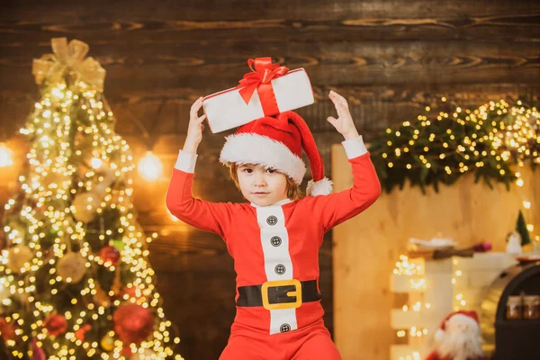 Świąteczne dziecko. Słodkie dziecko w pobliżu choinki. Szczęśliwe małe dziecko ubrane w zimowe ubrania pomyśl o Mikołaju w pobliżu choinki. — Zdjęcie stockowe