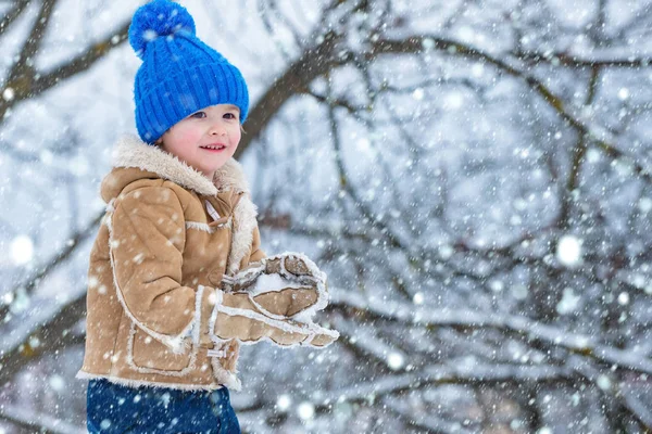 雪の中のクリスマスの子供たちテーマクリスマスの休日新年。冬の雪と子供のゲーム。子供のための幸せな冬の時間。冬の公園で楽しい時間を過ごしている楽しい小さな男の子. — ストック写真