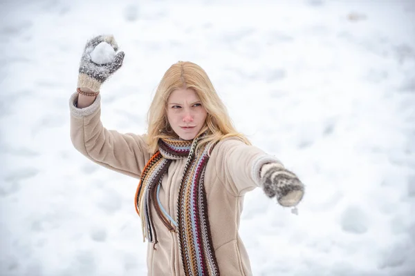 Χειμερινή γυναίκα. Χιονόμπαλα και χειμερινή διασκέδαση. Χαριτωμένο παιχνιδιάρικο νεαρή γυναίκα υπαίθρια απολαμβάνοντας το πρώτο χιόνι. — Φωτογραφία Αρχείου