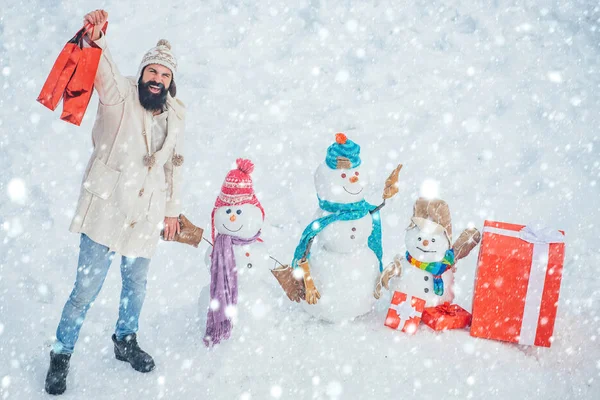 Hombre de Navidad en la nieve. Santa Claus desea Feliz Navidad. Tienda o tienda de Navidad. Hombre de Navidad y muñeco de nieve sobre fondo blanco . — Foto de Stock