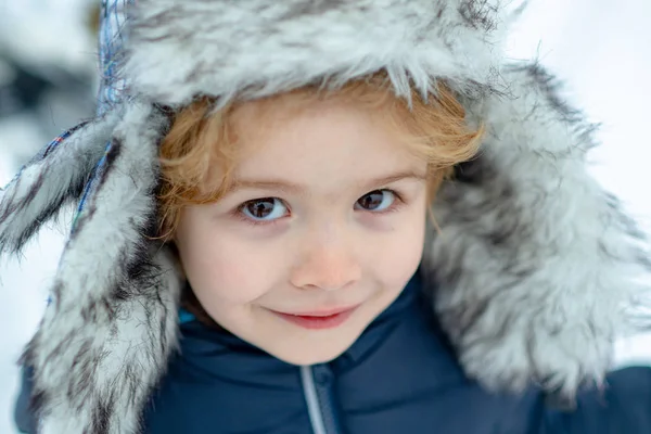 Winter child face close up. Happy child playing with snow on a snowy winter walk. Happy winter time. — Stock Photo, Image
