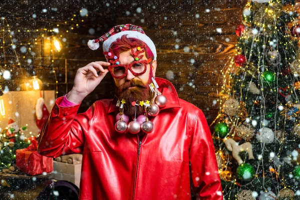 Kerstman in de sneeuw. Portret van een knappe kerstman binnenshuis met kerstcadeau. Kerst interieur en Home Christmas sfeer. Nieuwjaarsconcept. — Stockfoto