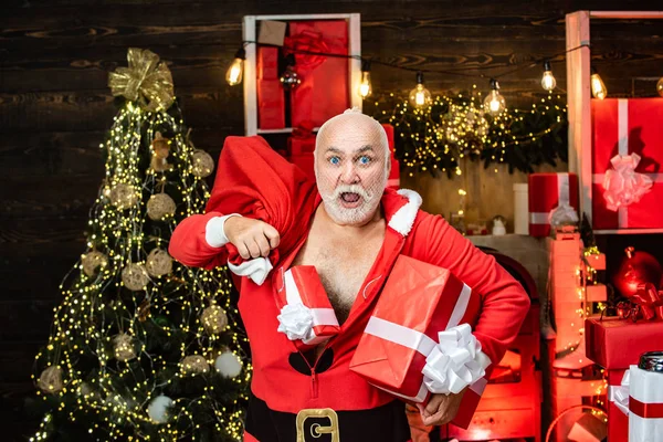 Einbrecher dringen maskiert ins Haus ein Lustig böser Weihnachtsmann mit Geschenk, Tüte mit Geschenken. Weihnachtsmann in der Maske mit Sack. — Stockfoto