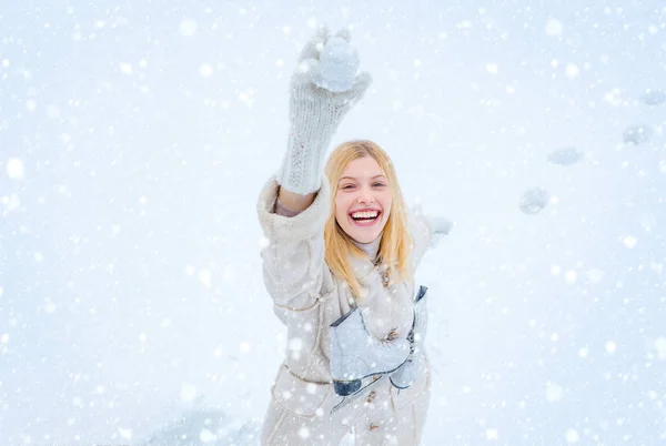 Woman in snow. Beautiful pretty young woman in winter. Young blond woman in sweater and funny hat holding white skates over shoulder in freezing winter day. — Stock Photo, Image