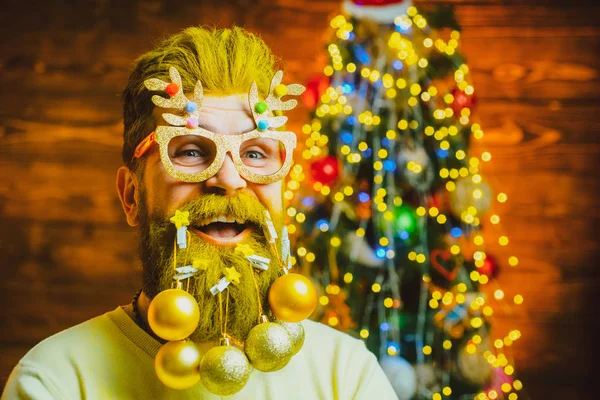 Hombre divertido de Santa posando sobre fondo de madera vintage. Papá Noel moderno barbudo en jersey de punto. Un hombre guapo vestido de Navidad. Concepto de año nuevo . —  Fotos de Stock