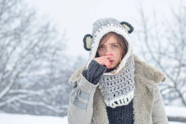 Sick in winter. Cold flu winter season, runny nose. Showing sick woman sneezing at winter park. Young woman blowing nose at snow winter background.