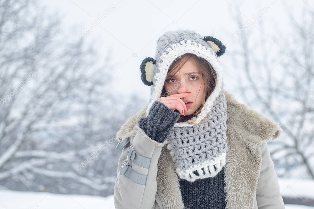 Sick in winter. Cold flu winter season, runny nose. Showing sick woman sneezing at winter park. Young woman blowing nose at snow winter background.
