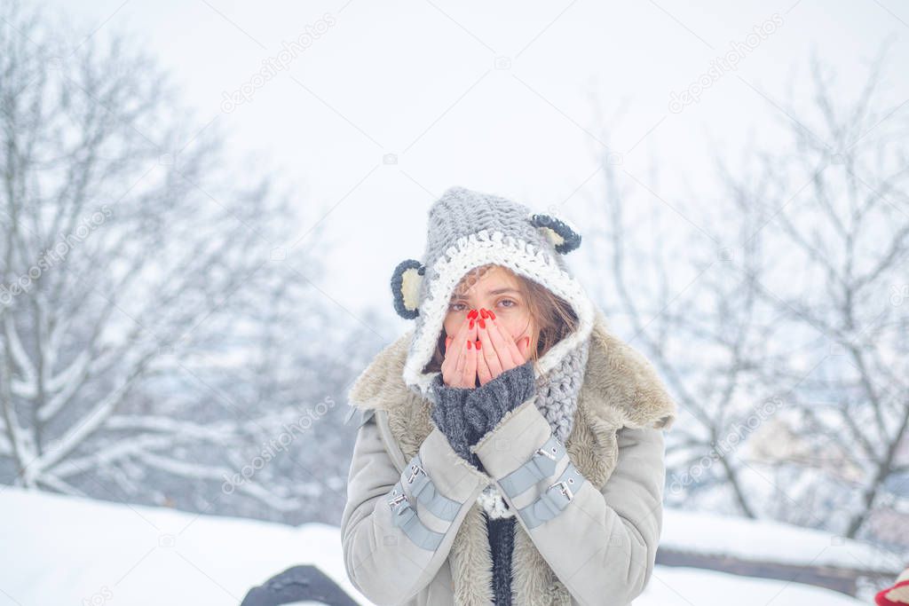 Sick winter girl with runny nose and fever. Sick people has runny nose. Woman makes a cure for the common cold in winter park.