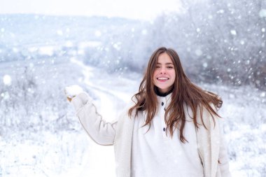Karla oynamak ve kış parkında eğlenmek. Kardaki kız. Kış yolculuğunda gülümseyen kız. Açık havada karla oynamak. Kış tatilinde eğleniyorum. Havanın ve karın tadını çıkarıyorum..