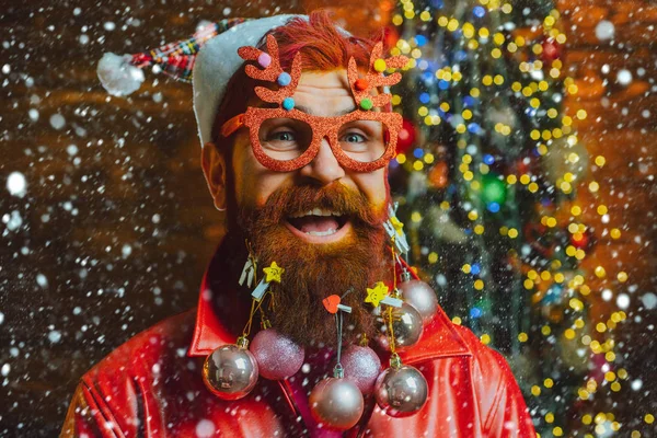 Hombre en la nieve. Feliz Navidad y feliz año nuevo. Nuevo año - fiesta divertida con Santa divertido. Concepto de barbería de Navidad o Año Nuevo. Barba con chuchería. Santa en la barbería. Estilo navideño para moderno —  Fotos de Stock