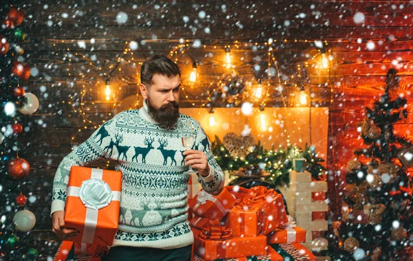 Muž ve sněhu. Vánoční muž v Santa klobouku. Vánoční ozdoby. Vánoční Santa přeje veselé Vánoce. Dárek pro Santa Clause. — Stock fotografie