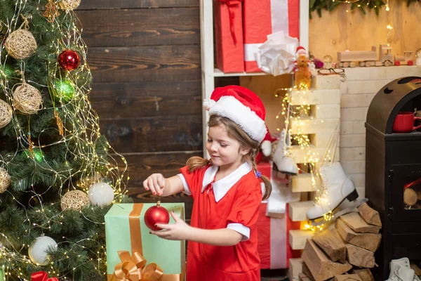 Ano Novo e conceito de crianças de Natal. Brinquedo de Natal - menina está decorando a árvore de Natal . — Fotografia de Stock