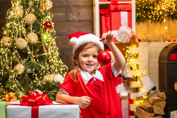 Ano Novo e conceito de crianças de Natal. Menina Decoração árvore de Natal em casa. Brinquedo de Natal - menina está decorando a árvore de Natal. — Fotografia de Stock