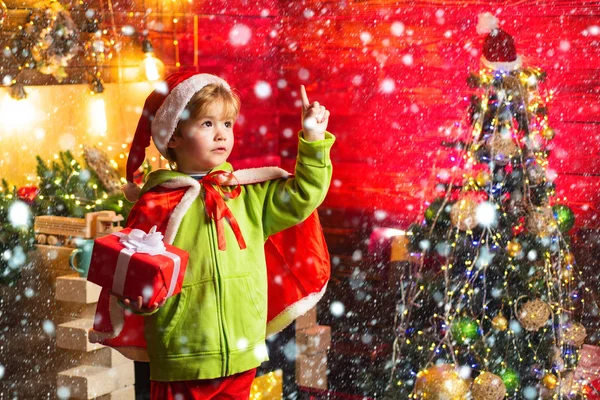 あなたの家族のために最高の願いこのクリスマス。メリークリスマスと幸せな新年。かわいい子供の男の子はクリスマスツリーの近くで遊ぶ。子供は家で冬の休日を楽しむ。喜びと愛に満ちた家 — ストック写真