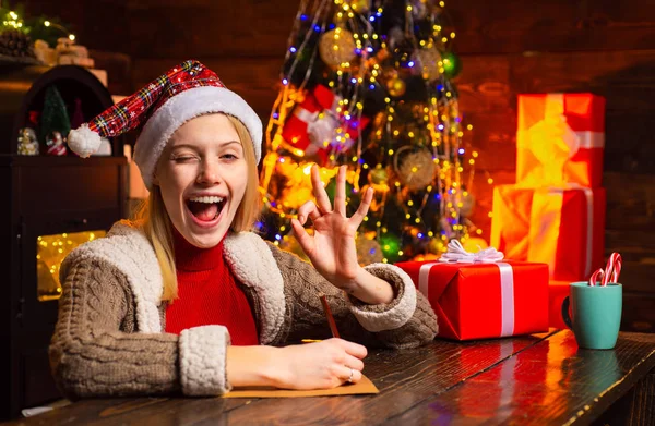 A mulher feliz está pronta para a véspera de Natal. Humor de Ano Novo. Uma mulher atraente numa sala de Natal. Dá uma piscadela. Cara cómica maluca. Arrepios de banda desenhada. — Fotografia de Stock