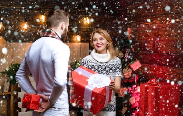Man handsome with gift box surprise for girlfriend. Couple in snow. Man hipster give gift to girl christmas decorations background. Surprise for sweetheart. Merry christmas and happy new year