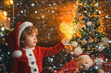 Kardaki çocuk. Parlak bir yeni yıl arifesi. Noel çelengi ışıkları. Noel 'i evde kutlayan çocuklu bir aile. Neşe ve mutluluk. Hediye kartı konsepti. Mutlu ve parlak noeller. Yeni Yıl.