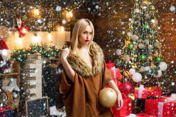 Meisje in de sneeuw. Mooie vrouw in kerstkleding op kerstboom achtergrond. Mooie vrouw die Nieuwjaar viert of een evenement. Vrouw met kerststemming. — Stockfoto