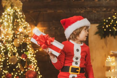 Çocuklar için kış teslimatı. Neşeli şirin çocuk Noel hediyesini açıyor. Noel kutlaması tatili. Noel 'den önceki sabah.