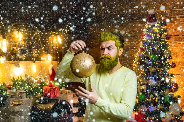 Homem na neve. Natal pessoas celebração Ano Novo. Ambiente de Natal em casa. Santa dentro de casa com bola de Natal, bugiganga de ouro . — Fotografia de Stock