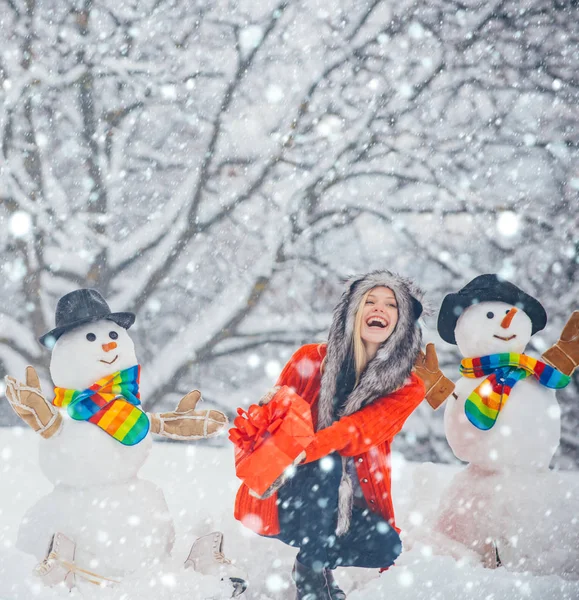 Funny snowmen. Merry Christmas and Happy Holidays. Christmas preparation - funny girl make snowman. Snowman and funny girl in the snow. Girl in snow. — Stock Photo, Image