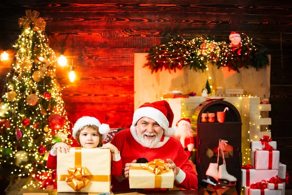 Papai Noel - pai e filho com uma bolsa cheia de presentes. Bebê adorável desfrutar de Natal. Ajudante de Pai Natal. Criança sonhadora na véspera de Natal . — Fotografia de Stock